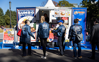 People standing in front of US Rice Food Truck serving gumbo at Japan Food Festival