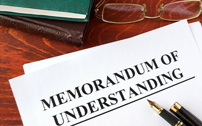 MOU Document with book, glasses, & pens TEST