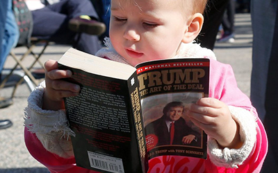 Baby reading Donald Trump
