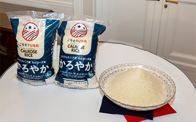 Bags of Calrose on table along with bowl of raw rice