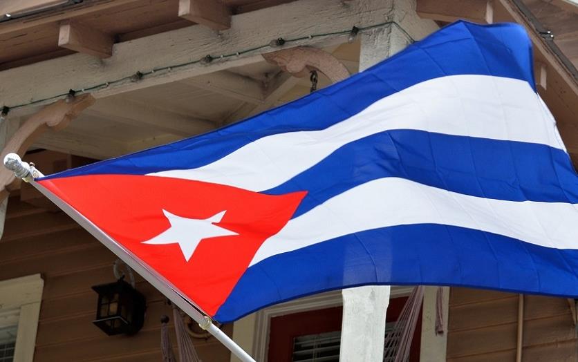 Cuban flag billowing in front of wooden porch