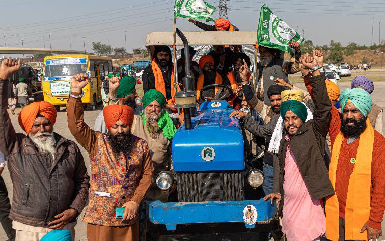 Farmers in India surround blue tractor during protest march