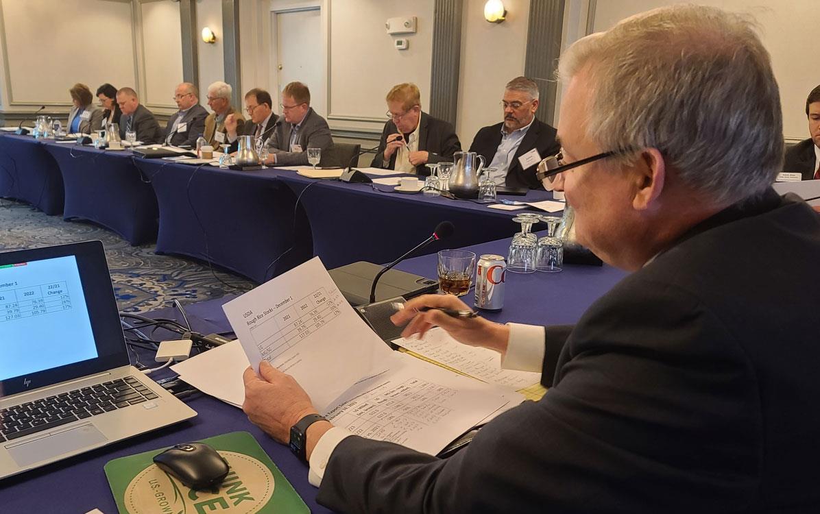 Feb 2023 WMP Mtg, Keith Glover presides with computer and ThinkRice mousepad at his left, members seated around table