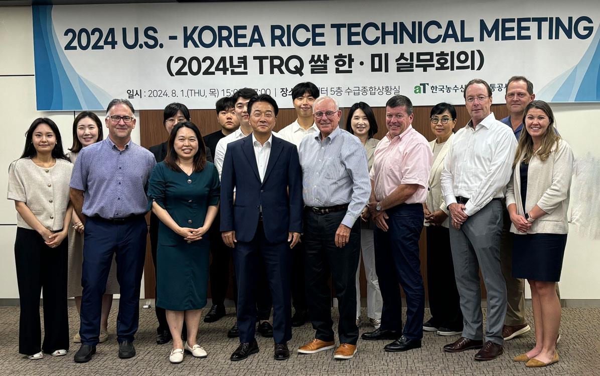 Korea-Tech-Mtg,-group-shot of people standing in front of banner announcing the meeting