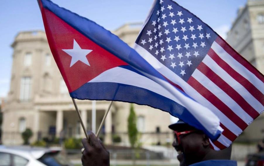 Man holding US & Cuban flags