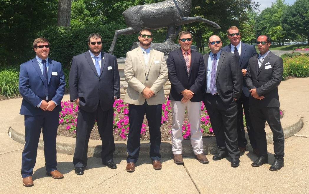 2019-21 Rice Leadership Class, group shot of men wearing suits and sunglasses standing in front of deer statue