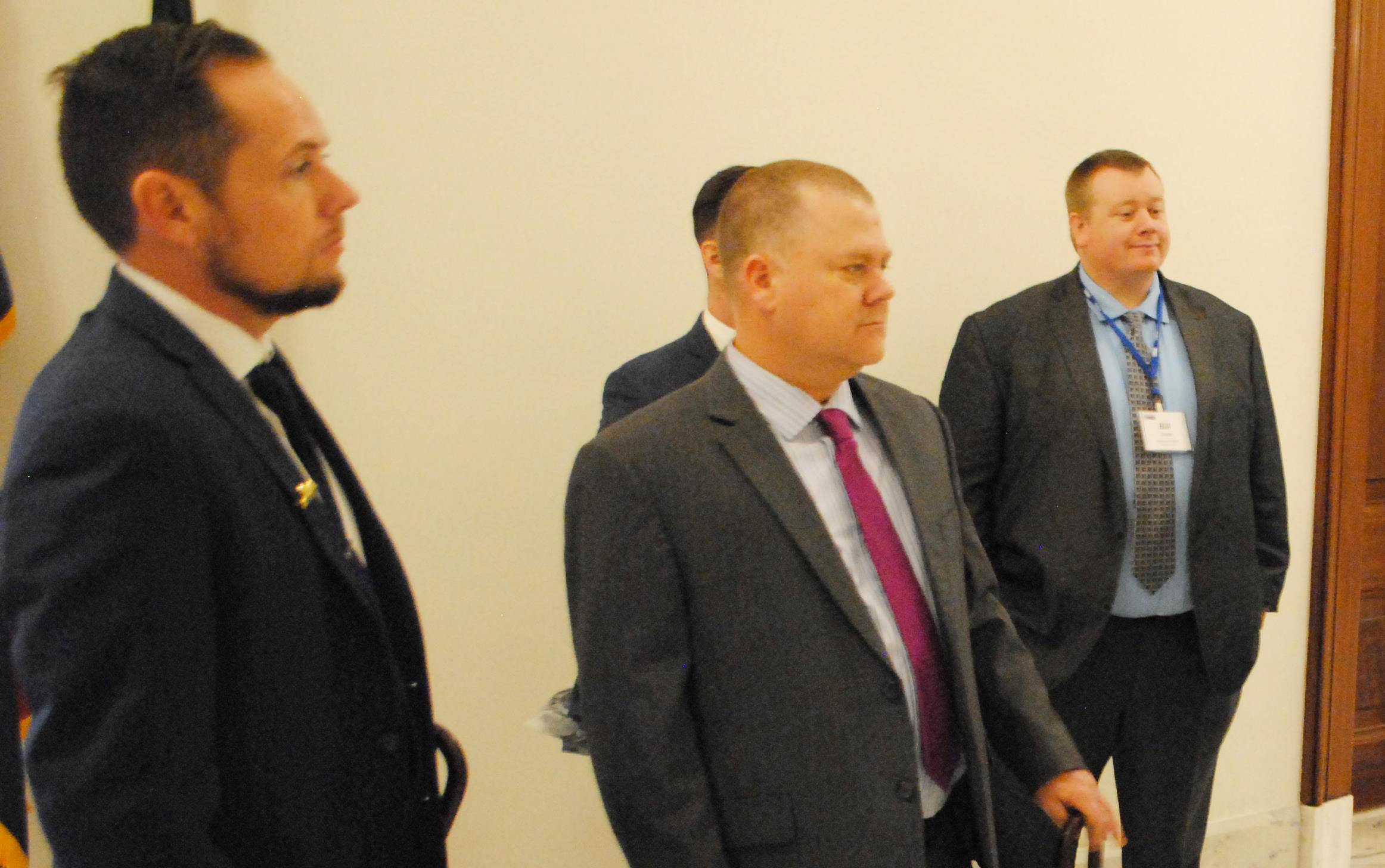 Group of people wearing business attire gather in hallway