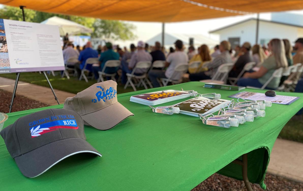 2021-CA-Field-Day,-swag-table in front of attendees sitting in chairs under a tent