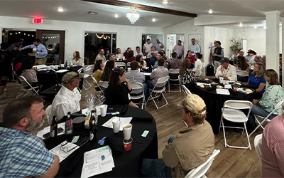 2025 LA Grower Mtg in Evangeline Parish, people sitting at tables listening to speaker