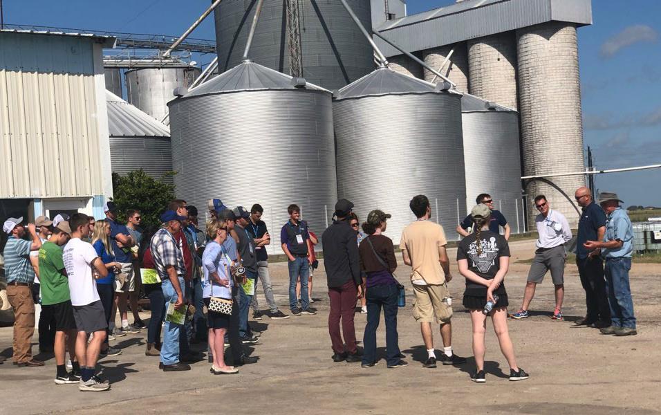 Group of Ag-Engineers-tour-Gertson-operation, stand in front of grain bins