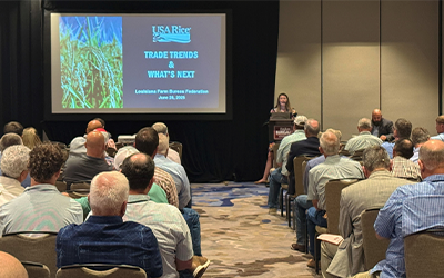 Karah Janevicius at podium giving trade talk at 2025 LA Farm Bureau Convention