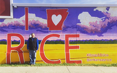 MK standing at AR Rice Mural