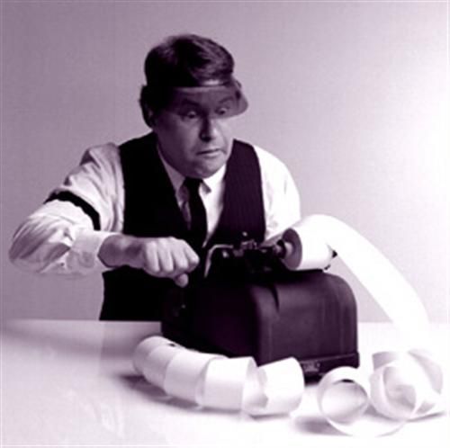 Accountant wearing visor and shirtbands works old fashioned adding machine
