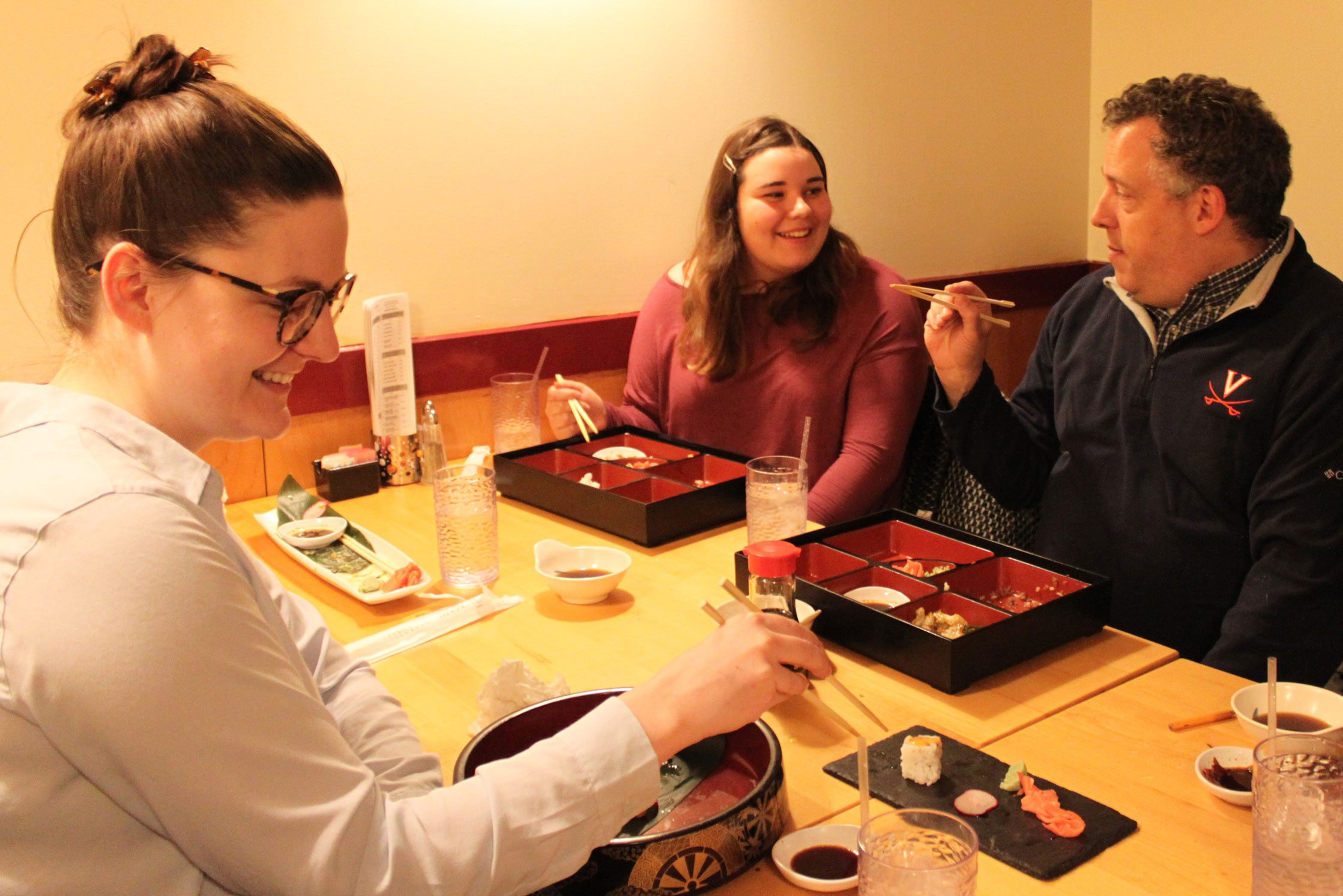 People using chopsticks to eat sushi at a restaurant