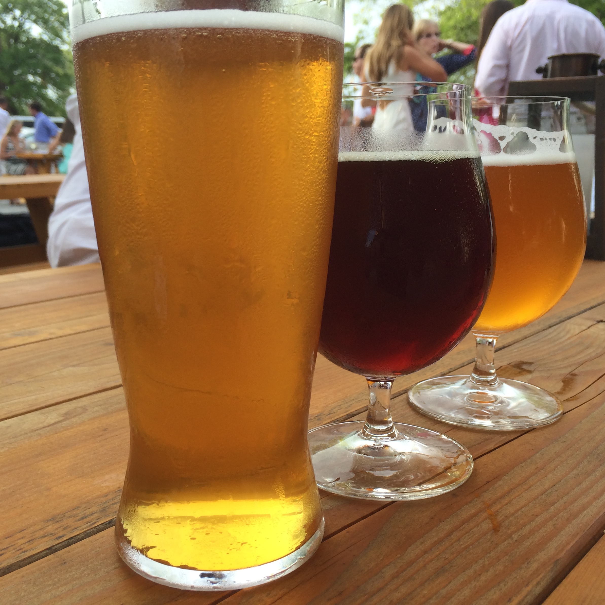 Three glasses of beer on a picnic table