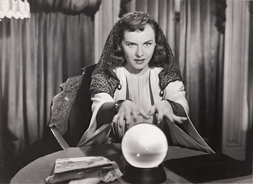 Female fortune teller with her hands over a crystal ball