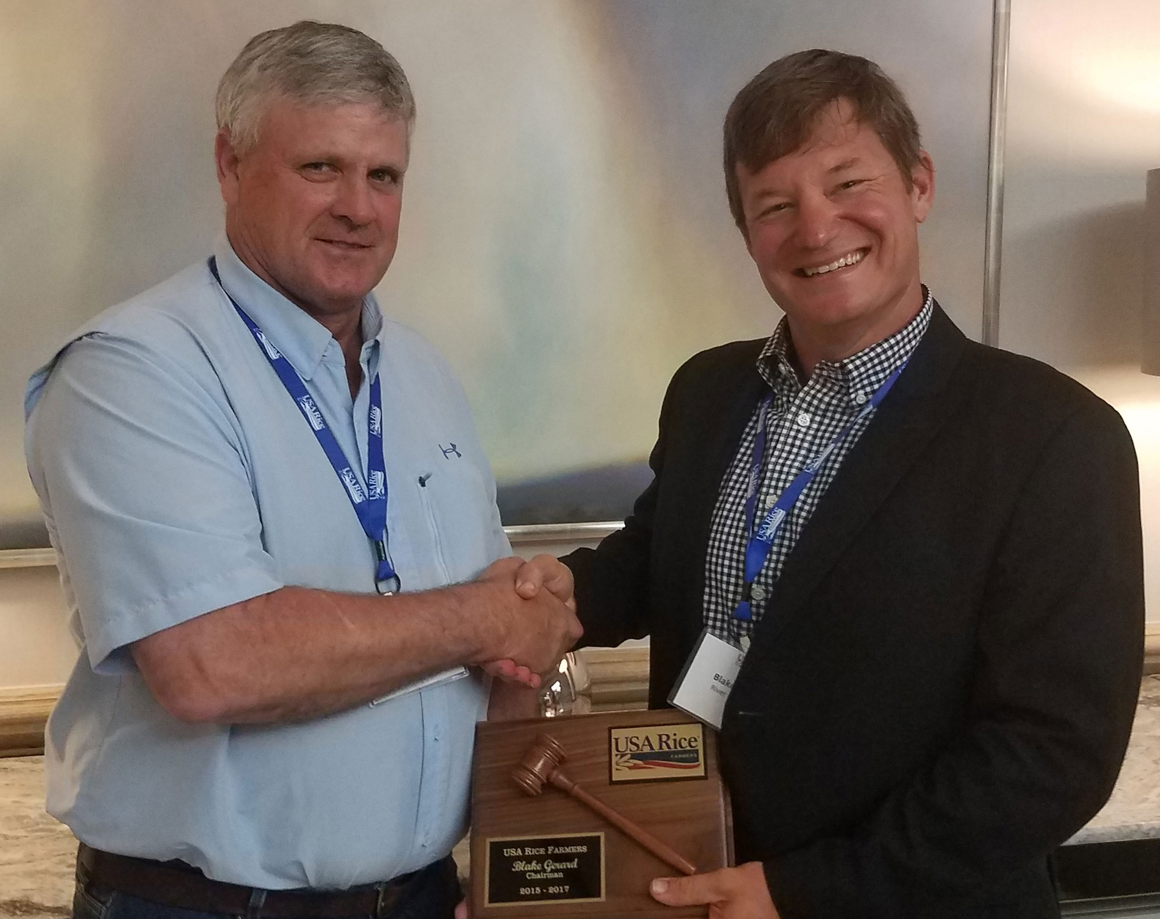 AR rice farmer Joe Mencer shakes hands and gives plaque to MO rice farmer Blake Gerard