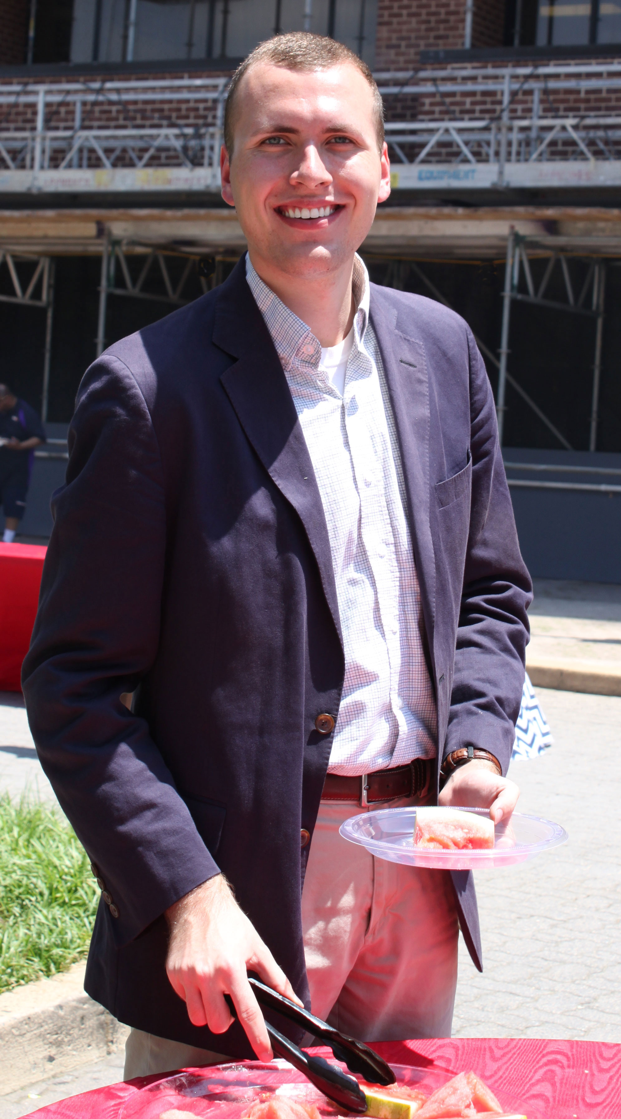 USA Rice intern Ethan-Cartwright eats watermelon at building cookout