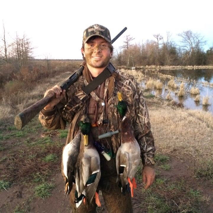 Photo of Government Affairs Intern-William-Mencer-after a duck hunt, wearing camo & carrying a gun
