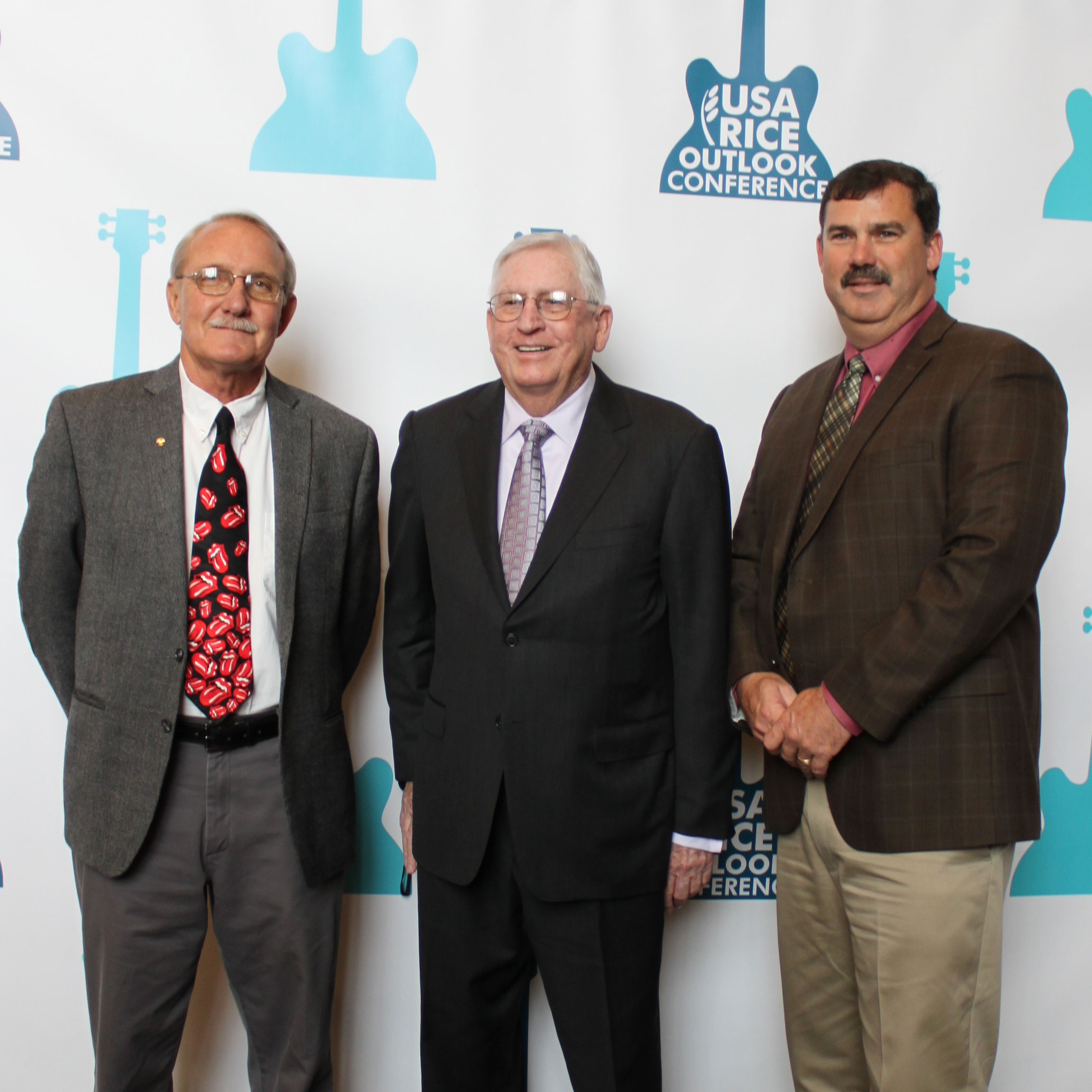 Three Rice-Award-Winners stand in front of 2016 Outlook step and repeat