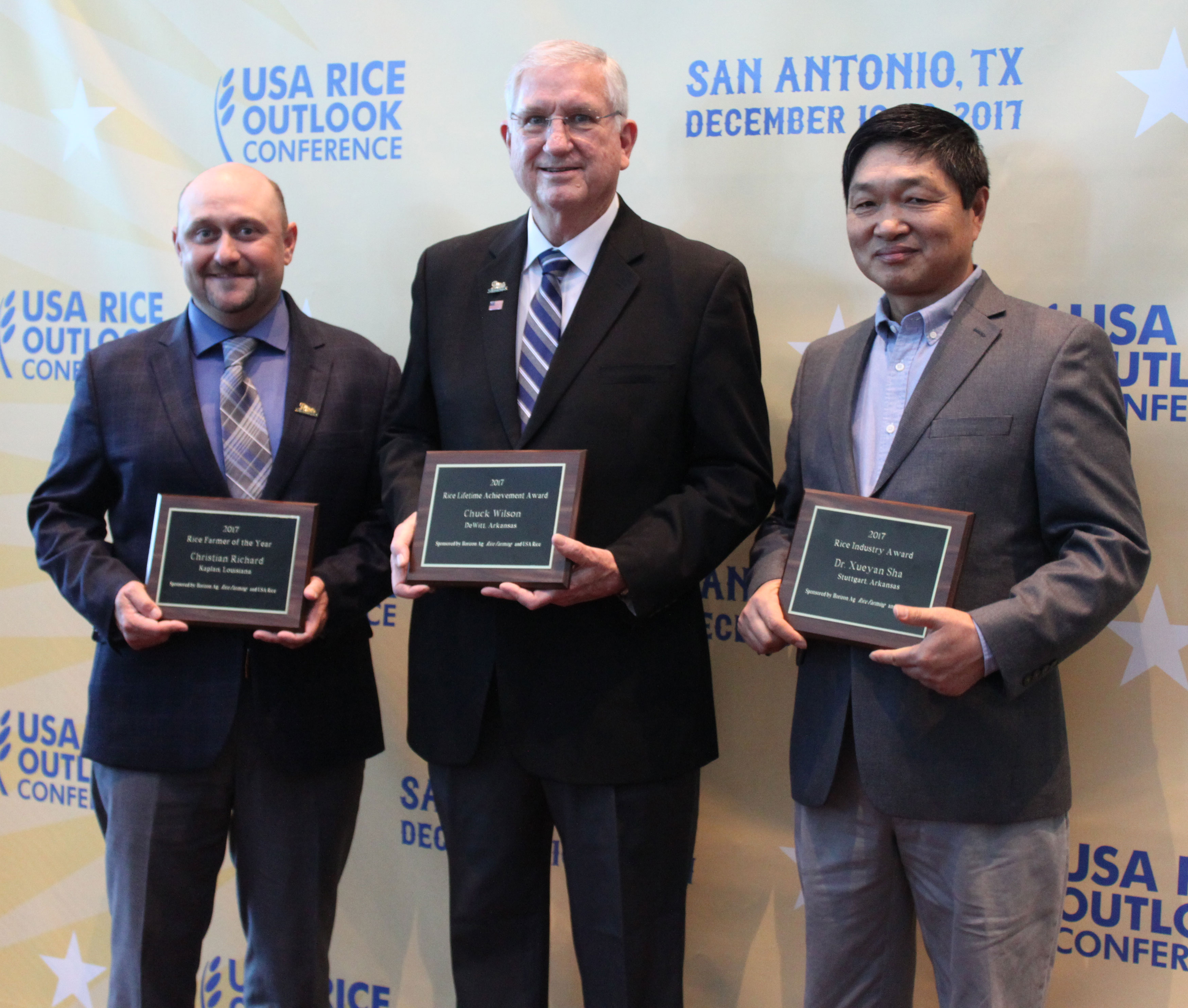 2017 Rice-Awards recipients holding plaques, standing in front of Outlook step-and-repeat