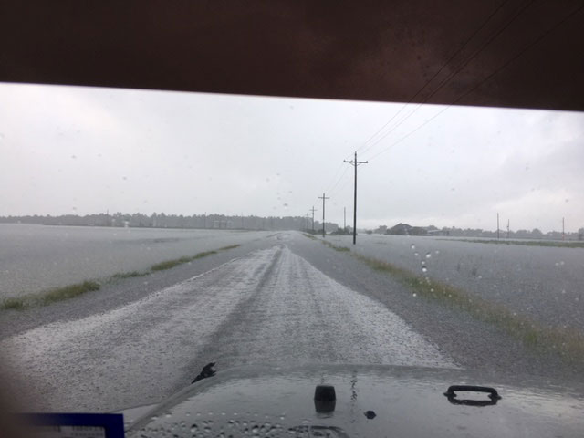 Photo taken from inside a pickup truck of flooded road and fields near Winnie TX during Hurricane Harvey