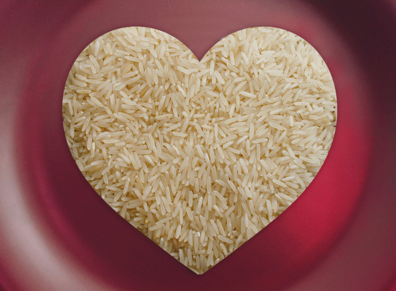 Heart-shaped rice on red background