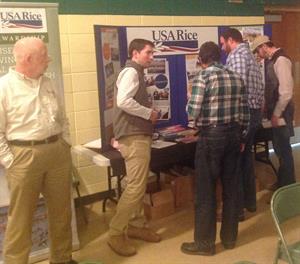 2016-mo-rice-conference, group of men stand around USA Rice booth