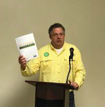 MK in yellow shirt stands at podium holding white piece of paper, NELA meeting 2018
