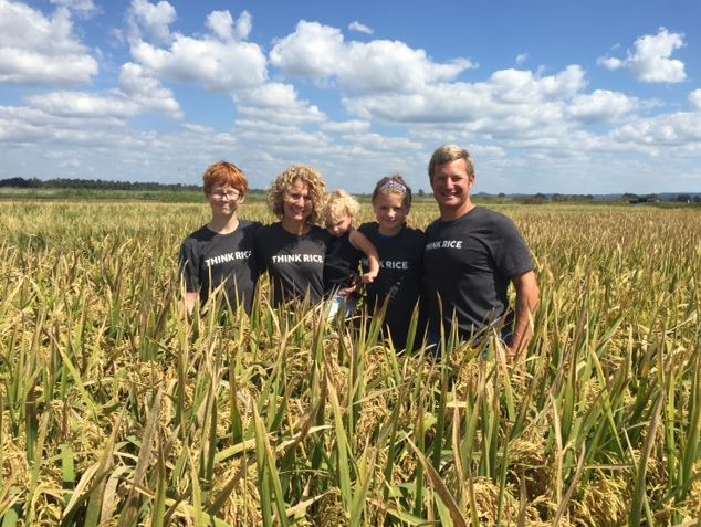 Blake Gerard and Family standing in field wearing Think Rice shirts