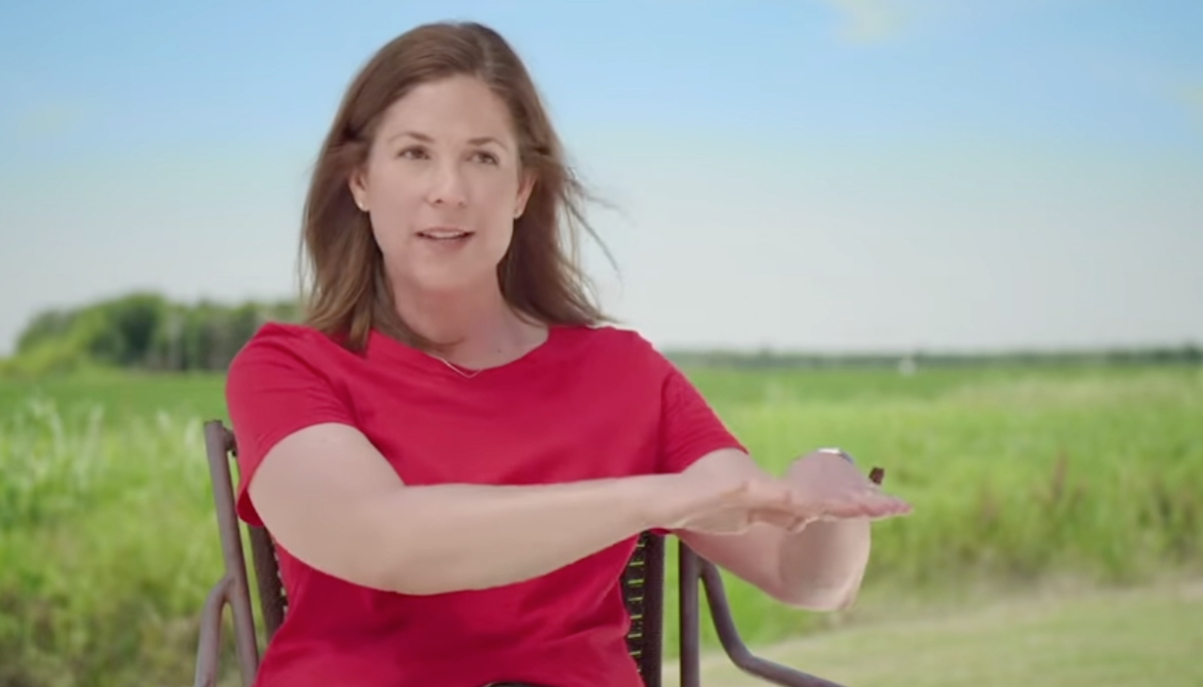 AR rice farmer Jennifer James sitting in front of rice field